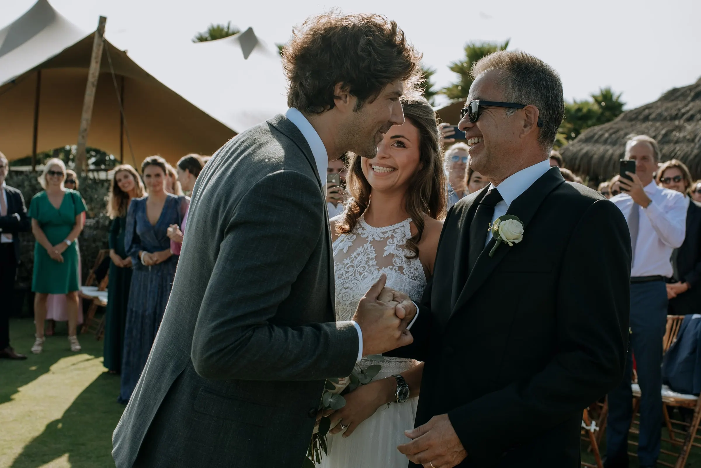 The groom embracing the bride's father after the ceremony, among the guests, Trocadero, Sotogrande