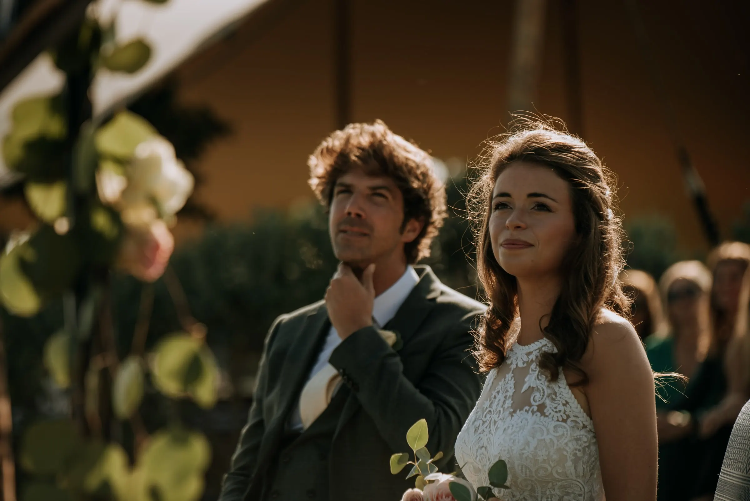 Bride and groom listening thoughtfully during the ceremony, framed by flowers, Trocadero, Sotogrande