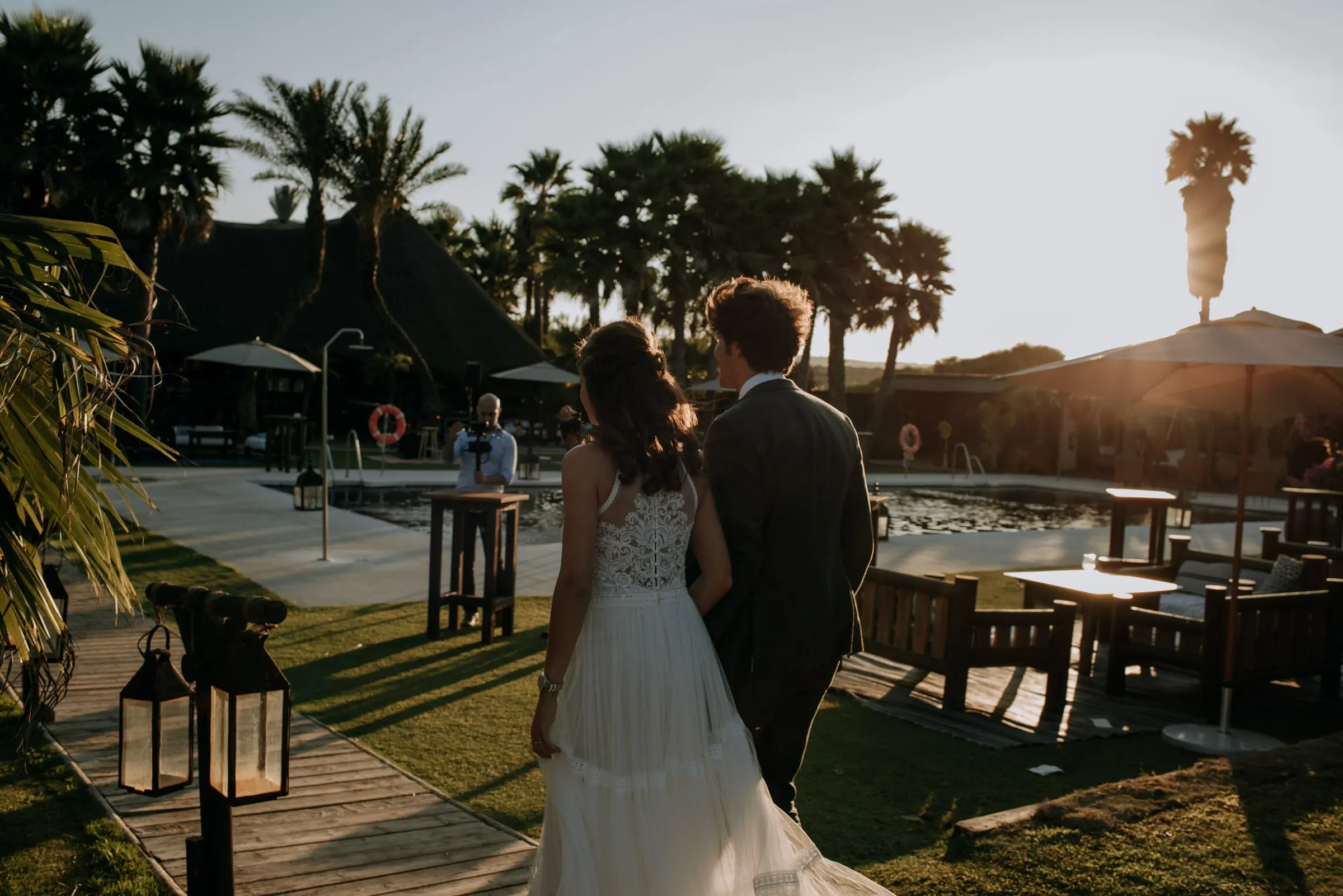 The couple seen from behind walking towards the pool at sunset, Trocadero, Sotogrande