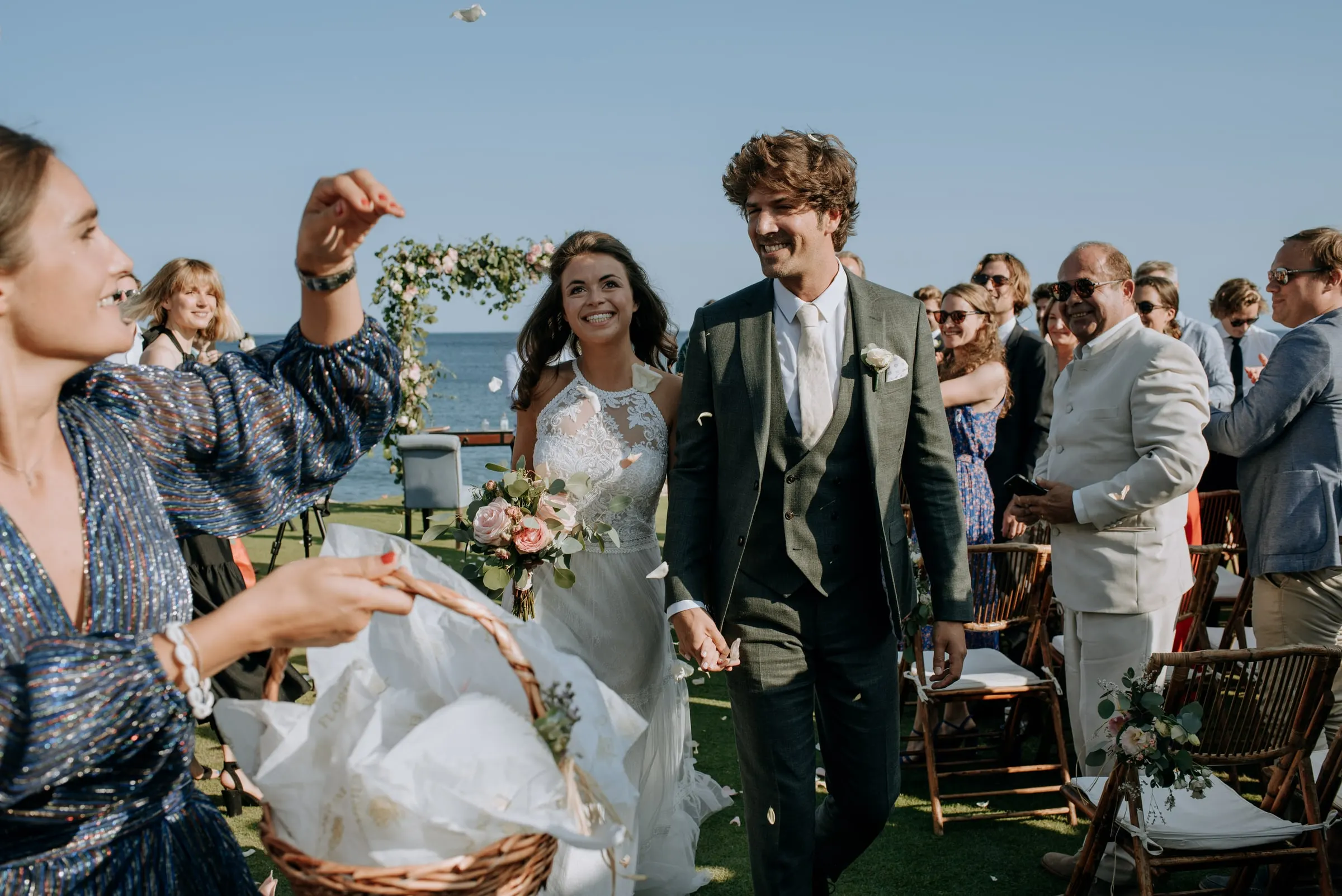 A guest throwing petals from a basket as the newlyweds walk past, Trocadero, Sotogrande