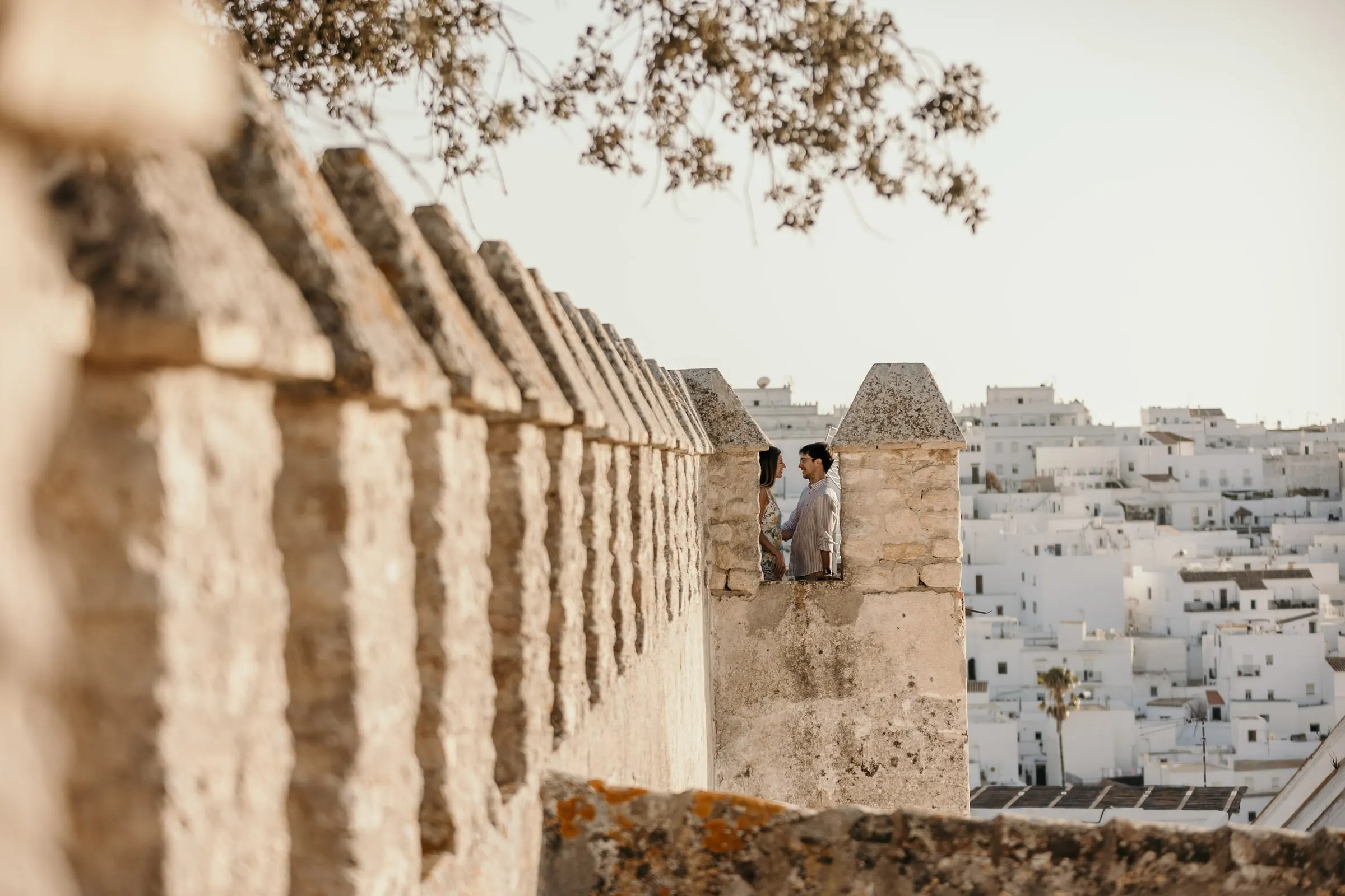 Couple on the battlements of Vejer castle with the white rooftops of the town beyond