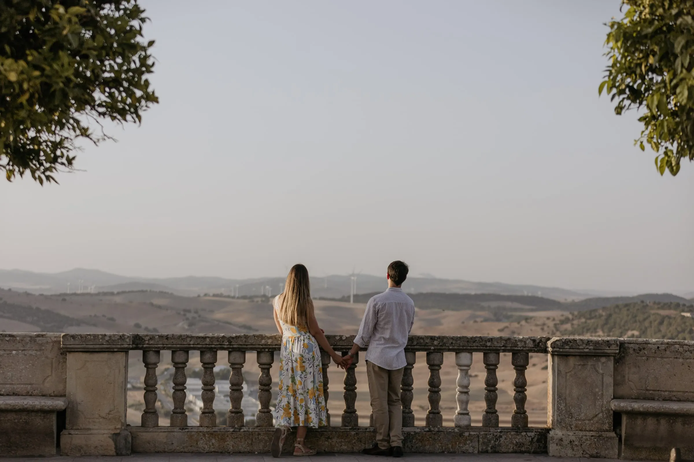 La pareja en un mirador con balaustrada contempla la campiña que rodea Vejer