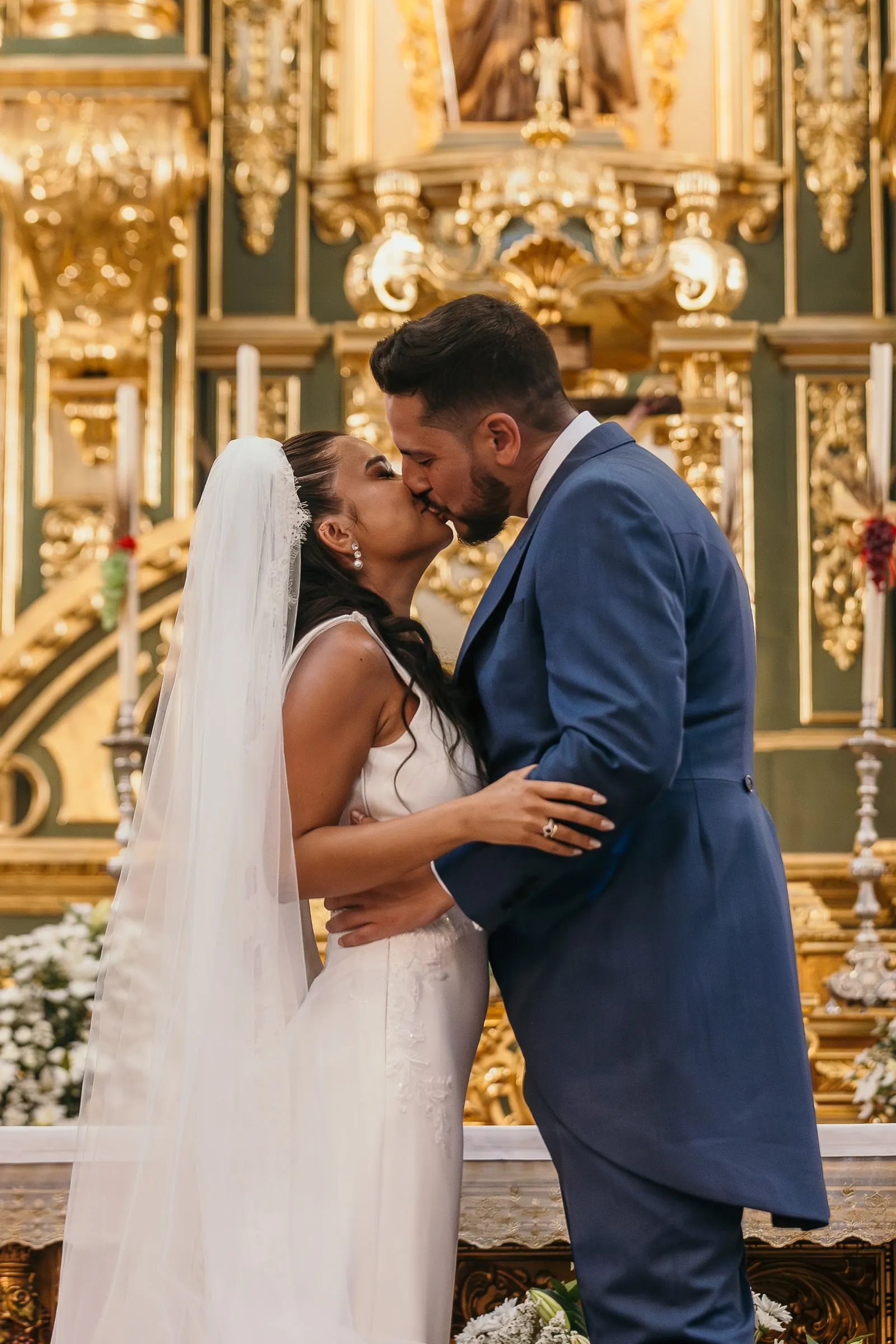 First kiss as husband and wife in front of the golden altarpiece