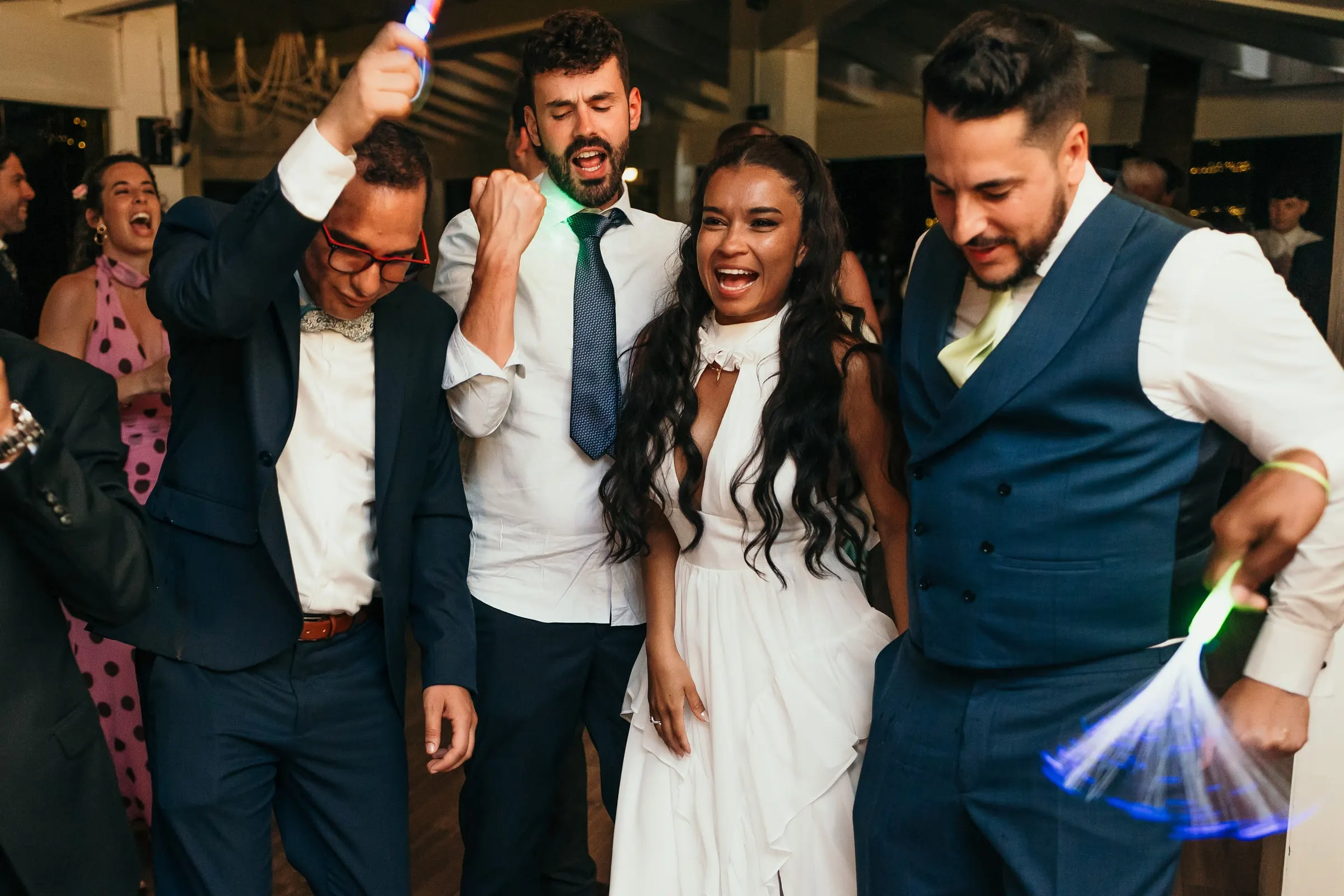 Bride in her second dress partying with the groom and friends on the dance floor